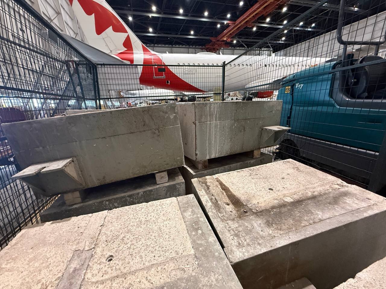 Cut concrete sections staged inside a Canadian airport hangar with an aircraft visible