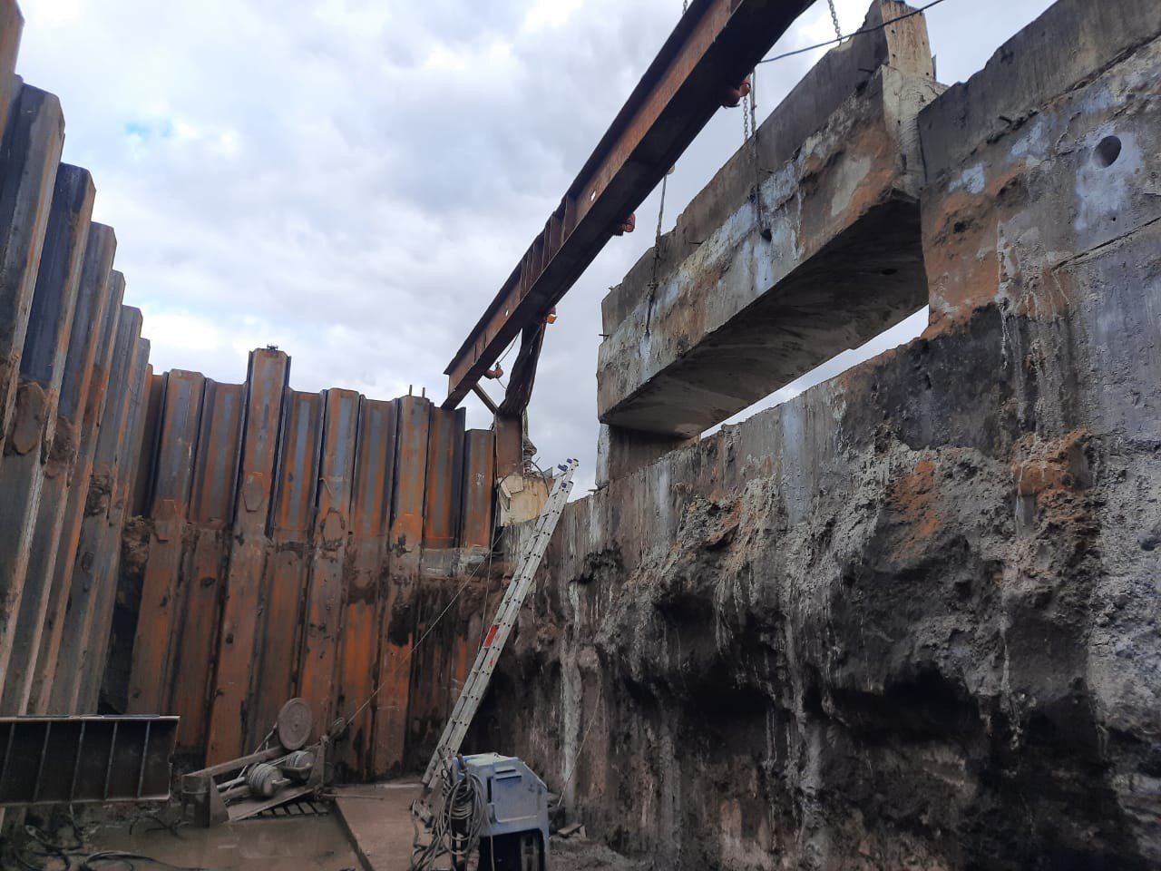 Reinforced-concrete excavation shoring section being lifted after wire sawing